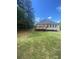 Backyard showing lawn, a home's wooden deck, and a metal carport at 1669 Azalea Dr, Lawrenceville, GA 30043