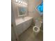 Well-lit bathroom with a vanity, sink, toilet, and a charming stained-glass window at 1669 Azalea Dr, Lawrenceville, GA 30043