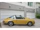An eye-level of a beautiful, canary yellow, classic sports car parked in front of a two-car garage at 1672 Dekalb Ne Ave # 2, Atlanta, GA 30307