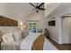 Cozy primary bedroom featuring high ceilings, a ceiling fan, a door leading to the deck, and a comfortable armchair at 270 Shady Marsh Trl, Roswell, GA 30075