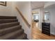 Carpeted staircase with wooden handrail leads to a hallway with hardwood floors and stylish decor at 270 Shady Marsh Trl, Roswell, GA 30075
