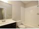 Bathroom featuring a dark vanity, a toilet, and a tub with white subway tile surround at 3220 Creole Ln, Avondale Estates, GA 30002