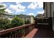 View from a wooden deck featuring a wood fence, trees, and neighboring townhomes under a blue sky at 3220 Creole Ln, Avondale Estates, GA 30002