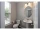 Well-lit half bathroom with a pedestal sink and oval mirror at 3220 Creole Ln, Avondale Estates, GA 30002