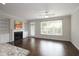 Spacious living room with a fireplace and built-in bookshelves is illuminated by natural light from a large window at 3220 Creole Ln, Avondale Estates, GA 30002