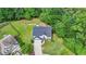 Aerial view of a charming two-story home with a well-manicured lawn and lush surrounding trees at 3668 Burel Mill Dr, Buford, GA 30519