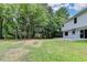 Back view of house with a large green backyard and patio, near a wooded area at 3668 Burel Mill Dr, Buford, GA 30519