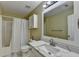 Bathroom with an enclosed shower/bathtub combo, toilet, and vanity with marble countertop at 3668 Burel Mill Dr, Buford, GA 30519