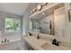 Luxurious bathroom featuring a dual-sink vanity, soaking tub, and a spacious glass shower at 3668 Burel Mill Dr, Buford, GA 30519