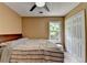 Bedroom with a ceiling fan, window overlooking the greenery, and a built-in closet at 3668 Burel Mill Dr, Buford, GA 30519