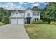 Charming two-story home with a well-manicured lawn, two-car garage, and inviting entrance at 3668 Burel Mill Dr, Buford, GA 30519