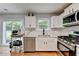 Bright kitchen featuring white cabinets, stainless steel appliances, and ample countertop space at 3668 Burel Mill Dr, Buford, GA 30519