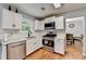 Modern kitchen with white cabinets, stainless steel appliances, and hardwood flooring at 3668 Burel Mill Dr, Buford, GA 30519