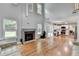 Open-concept living room featuring a fireplace, hardwood floors, and a view into the kitchen at 3668 Burel Mill Dr, Buford, GA 30519
