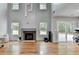 Spacious living room with fireplace, hardwood floors, and natural light from multiple windows at 3668 Burel Mill Dr, Buford, GA 30519