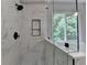 Modern shower with marble tile, black fixtures, built-in niche and a glass shower door at 3668 Burel Mill Dr, Buford, GA 30519