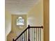 Stairwell with decorative light fixture, large windows, and wooden handrail at 3668 Burel Mill Dr, Buford, GA 30519