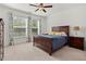 Spacious bedroom featuring a wooden bed frame, plush bedding, side tables, and large window with natural light at 5121 Aster Bnd, Canton, GA 30114