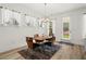 Cozy dining area with wood table, modern chairs, overhead lighting, and natural light streaming through large windows at 5121 Aster Bnd, Canton, GA 30114