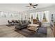 Bright, open-concept living area with wood floors, modern furnishings, and large windows providing plenty of natural light at 5121 Aster Bnd, Canton, GA 30114