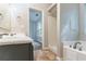 Bright bathroom featuring a shower, garden tub, and vanity sink at 7074 Springgrove Ct, Austell, GA 30168