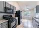 Eat-in kitchen with granite countertops, black appliances, and natural light at 7074 Springgrove Ct, Austell, GA 30168