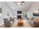 Staged living room featuring a cozy brick fireplace and large windows at 7074 Springgrove Ct, Austell, GA 30168