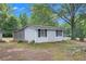 Cottage-style home with black shutters and mature trees offering a serene, wooded setting at 105 Tranquility Dr, Villa Rica, GA 30180