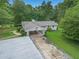 Ranch style home with attached carport and lush green lawn, surrounded by mature trees at 105 Tranquility Dr, Villa Rica, GA 30180