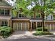 Traditional brick townhome with a two-car garage, charming entry porch and mature trees at 1203 Glenridge Ne Pl, Atlanta, GA 30342