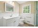 Bright bathroom featuring white vanity, toilet, wainscoting, neutral walls, and a large window at 175 Smith Ferguson Rd, Dallas, GA 30157