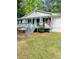 Inviting home featuring a covered front porch, American flag, and well-maintained lawn at 175 Smith Ferguson Rd, Dallas, GA 30157