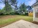 Well-maintained backyard with green grass, mature trees, and a concrete patio for outdoor entertaining at 3508 Sweetgum Ln, Decatur, GA 30032