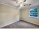 Neutral bedroom featuring plush carpeting, a ceiling fan, and a bright window at 3508 Sweetgum Ln, Decatur, GA 30032