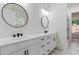 A luxurious bathroom featuring dual sinks, round mirrors and modern fixtures at 5567 Tyree Rd, Winston, GA 30187