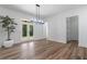 A dining room features an elegant chandelier, wood floors and outdoor views through double doors at 5567 Tyree Rd, Winston, GA 30187