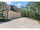 Spacious driveway leads to a bright home exterior with a two-car garage, surrounded by lush trees at 5567 Tyree Rd, Winston, GA 30187