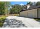 Charming home exterior featuring a wide driveway and a two-car garage with a wooded backdrop at 5567 Tyree Rd, Winston, GA 30187