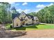 Beautiful home exterior with large lawn, framed by surrounding trees, under a blue sky at 5567 Tyree Rd, Winston, GA 30187