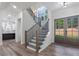 Welcoming foyer features a staircase, dark steel railings, and a view into the kitchen at 5567 Tyree Rd, Winston, GA 30187