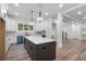 Modern kitchen with a dark brown island, white cabinets, stainless steel appliances, and wood flooring at 5567 Tyree Rd, Winston, GA 30187