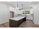 Well-lit kitchen featuring white cabinets, stainless steel appliances, and a large island with a stone countertop at 5567 Tyree Rd, Winston, GA 30187
