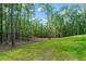 Beautiful wooded lot featuring a lush green lawn area and mature trees, providing a serene natural setting at 5567 Tyree Rd, Winston, GA 30187