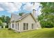 The backyard has a well-manicured lawn and features a tall chimney, siding, and a set of windows at 6027 Windfall Ct, Powder Springs, GA 30127