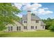 The home's backyard features a well-manicured lawn, a concrete patio, and mature trees at 6027 Windfall Ct, Powder Springs, GA 30127