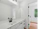Bathroom with white cabinets, black hardware, and a large mirror at 6027 Windfall Ct, Powder Springs, GA 30127