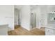 Bright bathroom featuring a glass shower, wood-look floor, and neutral color palette at 6027 Windfall Ct, Powder Springs, GA 30127