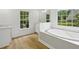 Bright bathroom with soaking tub, a marble countertop vanity, and a large window providing great views at 6027 Windfall Ct, Powder Springs, GA 30127