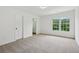 Bedroom features a bright window, carpet, and white trim at 6027 Windfall Ct, Powder Springs, GA 30127