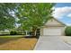 The exterior showcases a well-maintained lawn, mature tree and a driveway leading to the garage at 6027 Windfall Ct, Powder Springs, GA 30127
